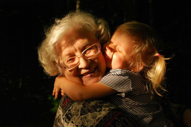 Großmutter wird von ihrem Enkelkind umarmt
